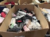 many pairs of shoes in a cardboard box on the floor