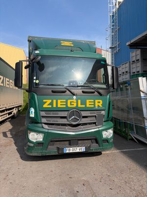 un camion vert garé à côté d'un autre camion