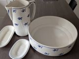 a pitcher, bowl, and spoon sitting on a table