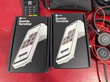 two boxes of remotes sitting on a table next to each other