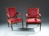 pair of red upholstered armchairs in the style of louis xvi