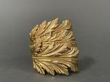 a close up of a gold ring with leaves on it