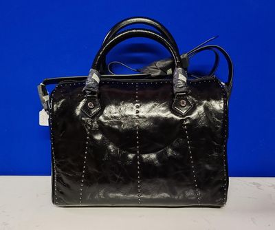 un sac à main noir posé sur une table blanche