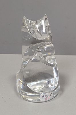 une figurine de chat en verre posée sur une table