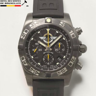 une montre noire avec une trotteuse jaune sur fond blanc