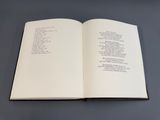 un livre ouvert posé sur une table, sur fond noir