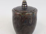 a close up of a ceramic container on a white surface