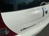 a small white car parked on the side of the road