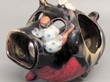 a figurine of a pig with a little girl on it