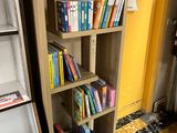 a bookshelf with many books on it in a room