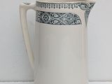 cream pitcher with blue and white design on the rim