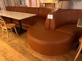 a corner booth with a table and chairs in the corner