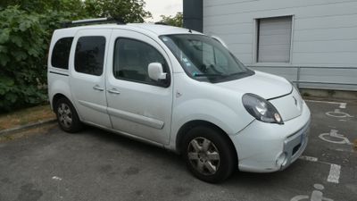 une petite camionnette blanche garée dans un parking