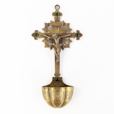 an antique brass crucift with a cross and a green bead
