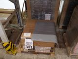 un lit au milieu d'une pièce, avec des cartons par terre