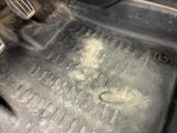 a dirty floor in a car with a dirty floor mat