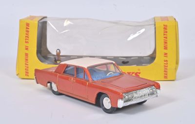 une petite voiture rouge devant une boîte jaune