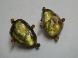 deux perles de verre jaunes et vertes posées sur une surface blanche