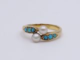 a close up of a gold ring with pearls and turquoise stones