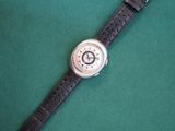 a close up of a watch on a green surface