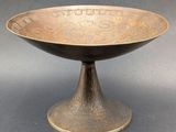 an image of a metal bowl on a pedestal on a gray surface