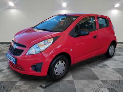 La Chevrolet Spark rouge est garée dans une pièce au sol carrelé