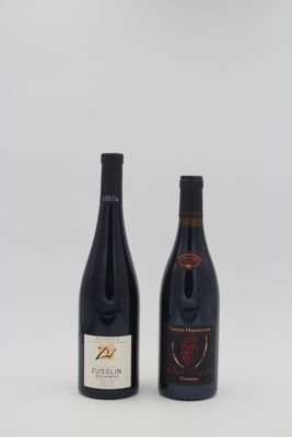 deux bouteilles de vin posées l'une à côté de l'autre sur une surface blanche