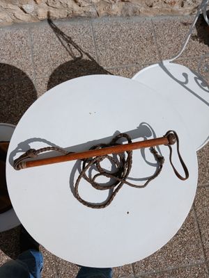 une assiette blanche munie d'un manche en bois et d'une corde