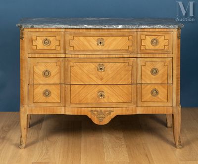 une commode ancienne avec un plateau en marbre posée sur un parquet