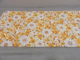 a close up of a yellow and white flowered placemat