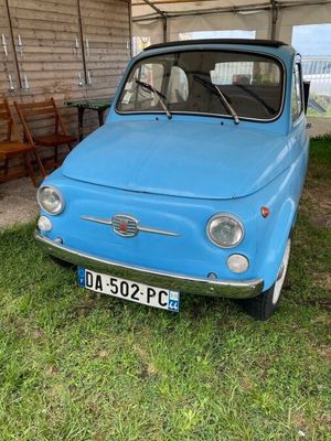 une petite voiture bleue garée dans l'herbe