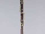 a close up of a clarinet on a stand with a grey background
