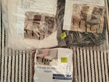 two bags of cat food on a bed with a cat sitting on it