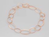 un gros plan d'un bracelet à chaîne dorée sur fond gris