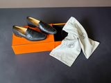 pair of black leather shoes in a box with a white cloth