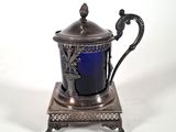silver plated teapot on stand with blue glass in it