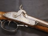 a close up of a gun with a wooden handle on a black background