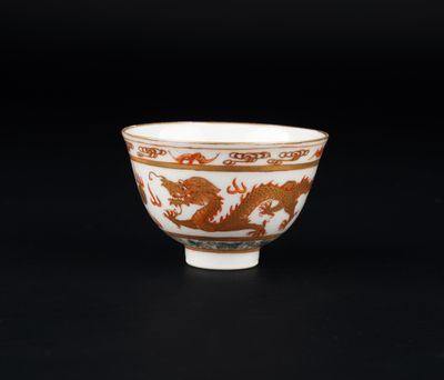 un bol orange et blanc orné d'un motif représentant un dragon