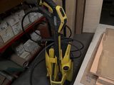 un nettoyeur haute pression jaune et noir rangé dans un garage