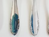 three spoons and two spoon spoons hanging on a wall