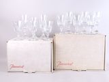 several empty wine glasses sitting in a box on a white surface