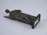 bronze statue of a woman laying on a bench with a clock in her hand