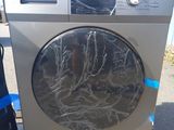 une machine à laver posée sur une palette devant un immeuble