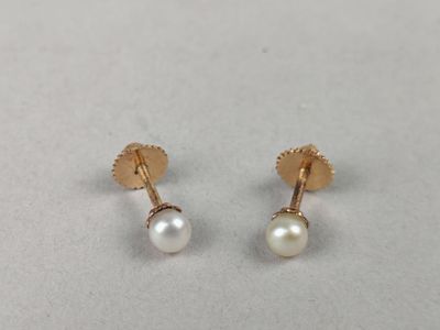 a pair of pearl earrings on a white surface