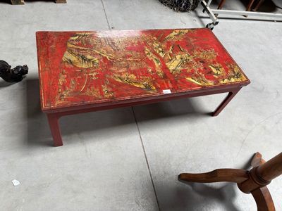 une table rouge ornée d'un motif à la feuille d'or