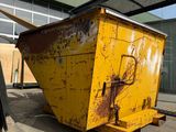 a large yellow dumpster sitting in front of a building