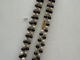 a close up of a necklace with pearls and a gold clasp