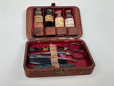 une petite trousse contenant une paire de ciseaux et un flacon de médicament