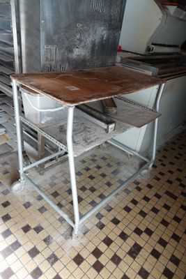 a table and chair in a kitchen with a stove in the background
