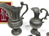 three silver vases sitting next to each other on a table
